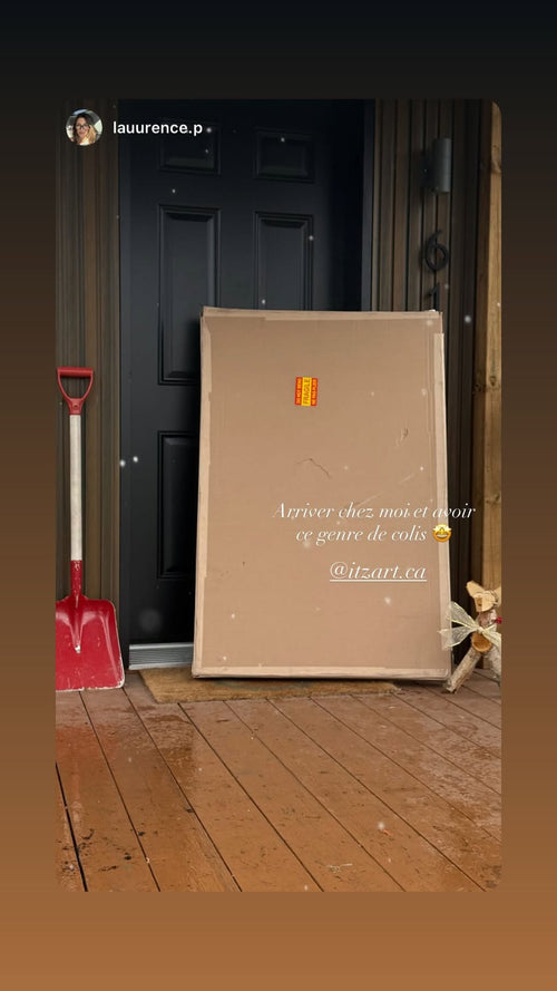 Large flat ItzArt package marked fragile at a front door, with a French caption celebrating its arrival.