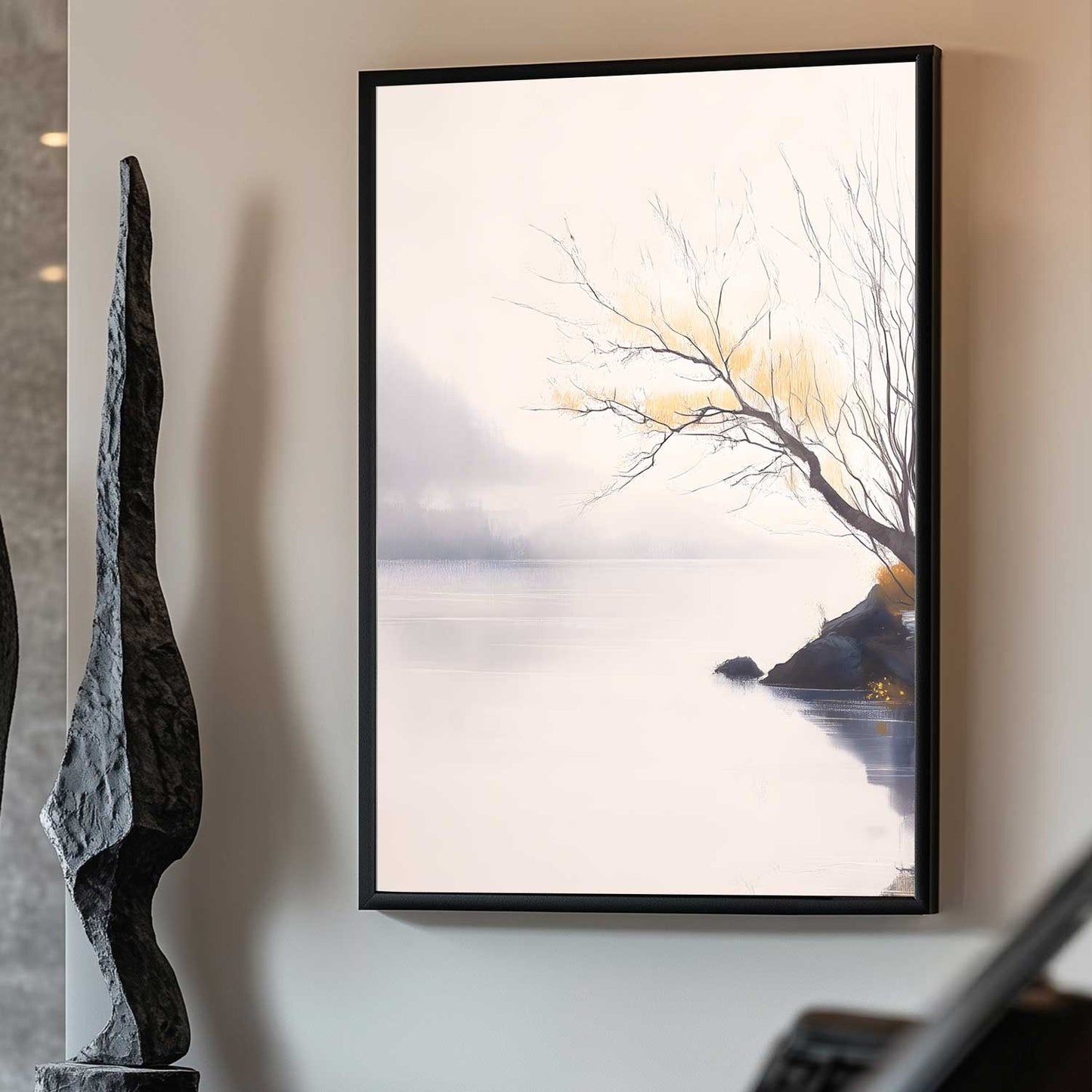 Framed artwork of a tree by a lake on a wall next to a sculpture.