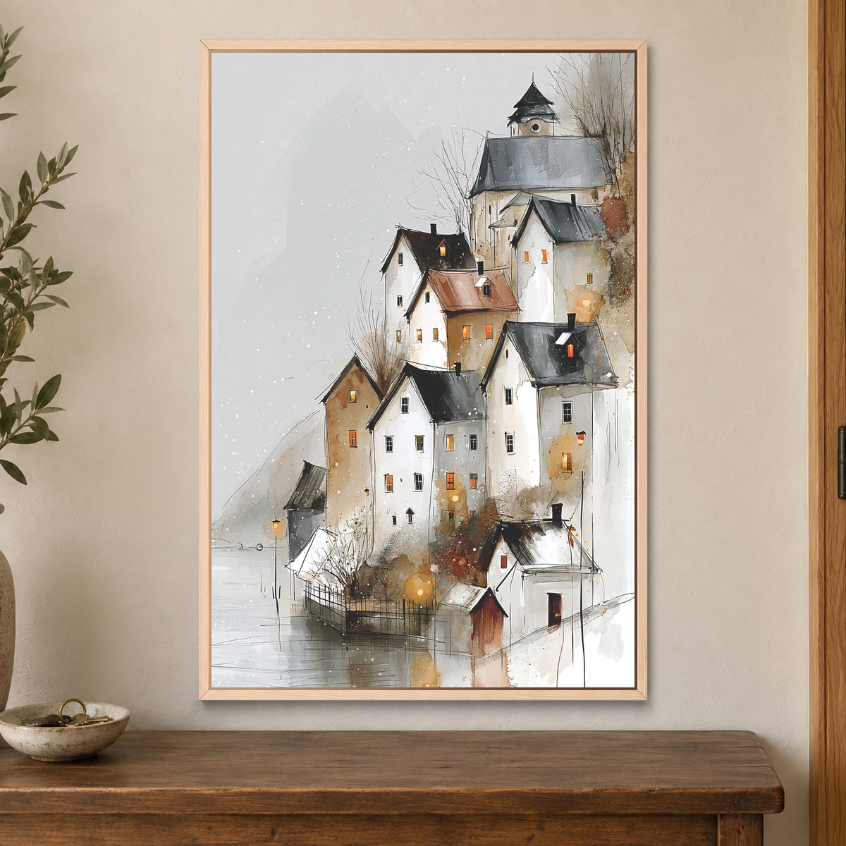Hallstatt Austria Winter Rooftops framed canvas in a natural wood floating frame on a cream wall above a wooden sideboard beside a door frame