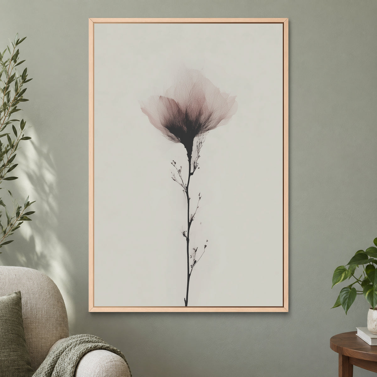Single Stem Pink Bloom framed canvas in a natural wood floating frame on a sage green wall beside a cream armchair