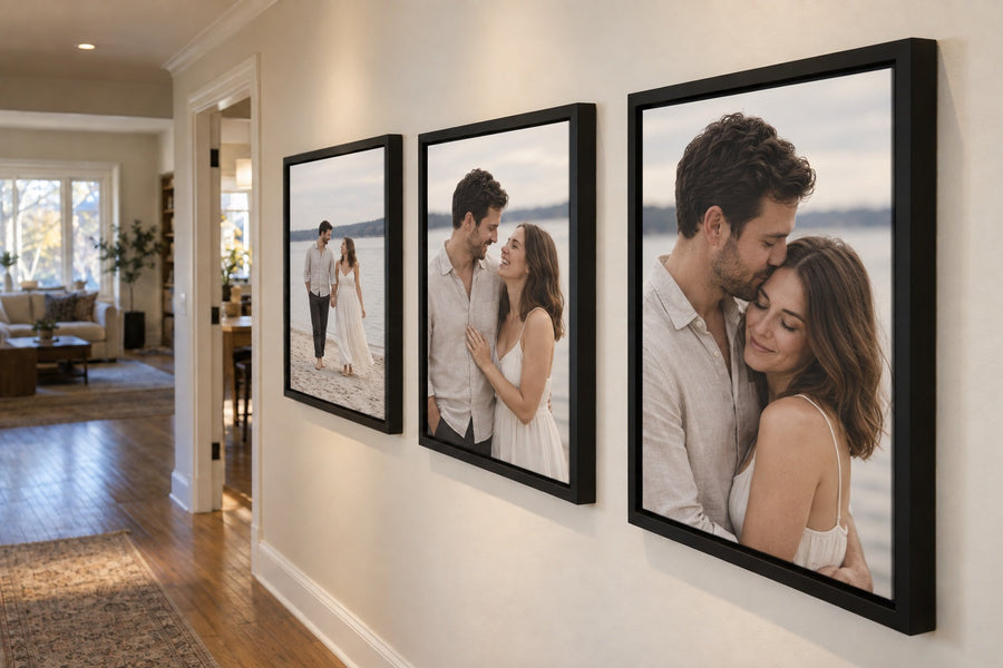 alt="Three engagement photos of the same couple displayed in satin black floater-framed canvases along a warm, sunlit hallway.