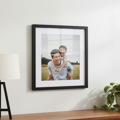 Black frame photograph with white mat of a man and child