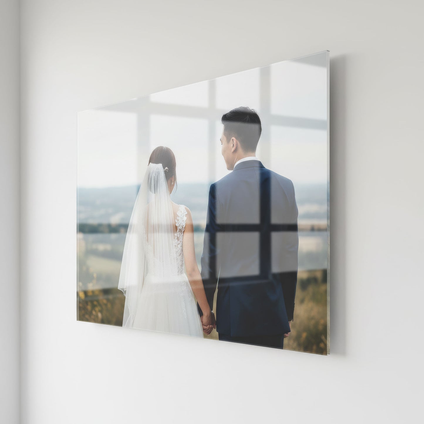 Acrylic photo print of a bride and groom holding hands with a scenic background.
