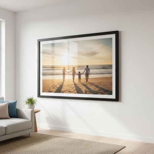 Black framed family photo print on a beach at sunset in a living room.