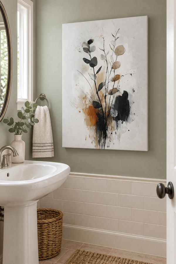 Unframed eucalyptus canvas beside a pedestal sink in a pale sage bathroom.