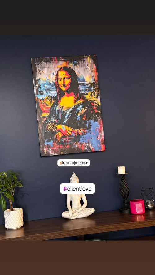Colourful Mona Lisa pop art displayed on a navy wall above a wooden console with a Buddha statue and candles.