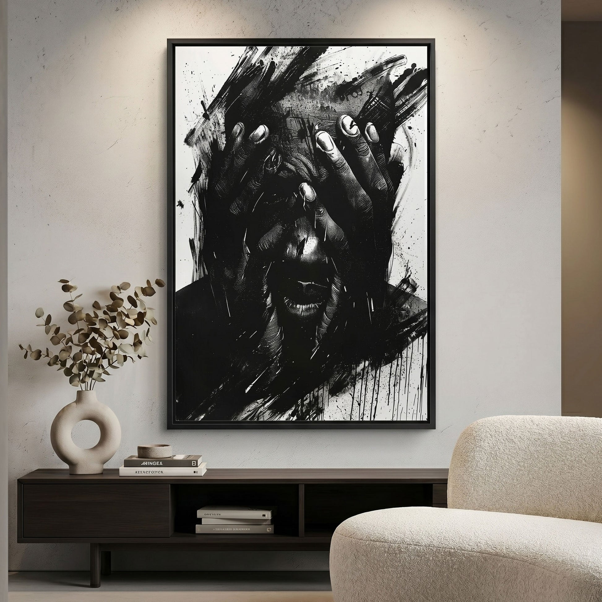 Framed black and white abstract art piece on a wall above a shelf with decor items.