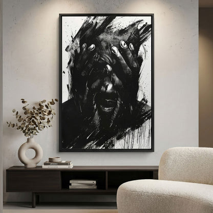 Framed black and white abstract art piece on a wall above a shelf with decor items.