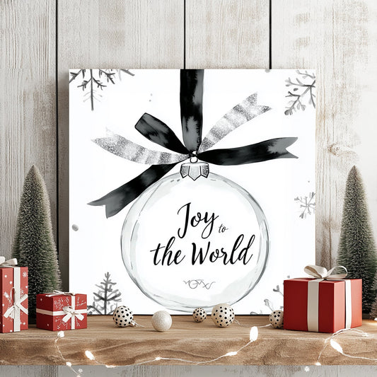 Black-and-white illustration of a holiday ornament with the phrase “Joy to the World” and surrounding snowflakes.