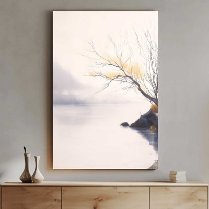 Framed artwork of a tree by a body of water on a wall above a wooden cabinet.