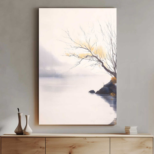Framed artwork of a tree by a body of water on a wall above a wooden cabinet.