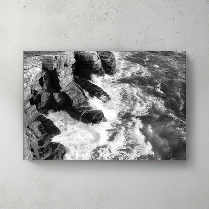 A black-and-white portrayal of rugged cliffs against the relentless ocean waves. Perfect for modern decor. canvas wall art abstract portrait landscape