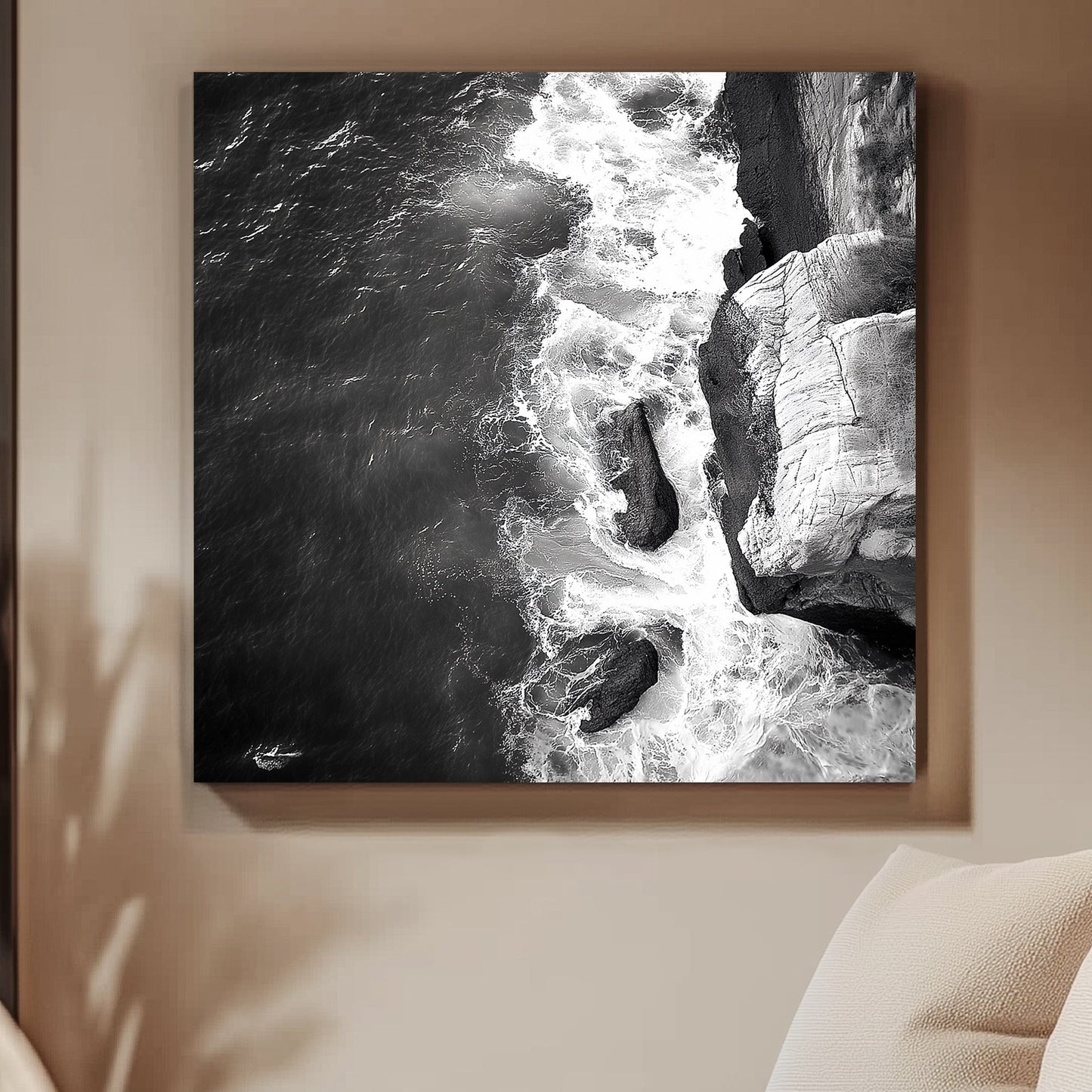 Black and white image of waves crashing against rocky cliffs, creating a dramatic coastal scene.