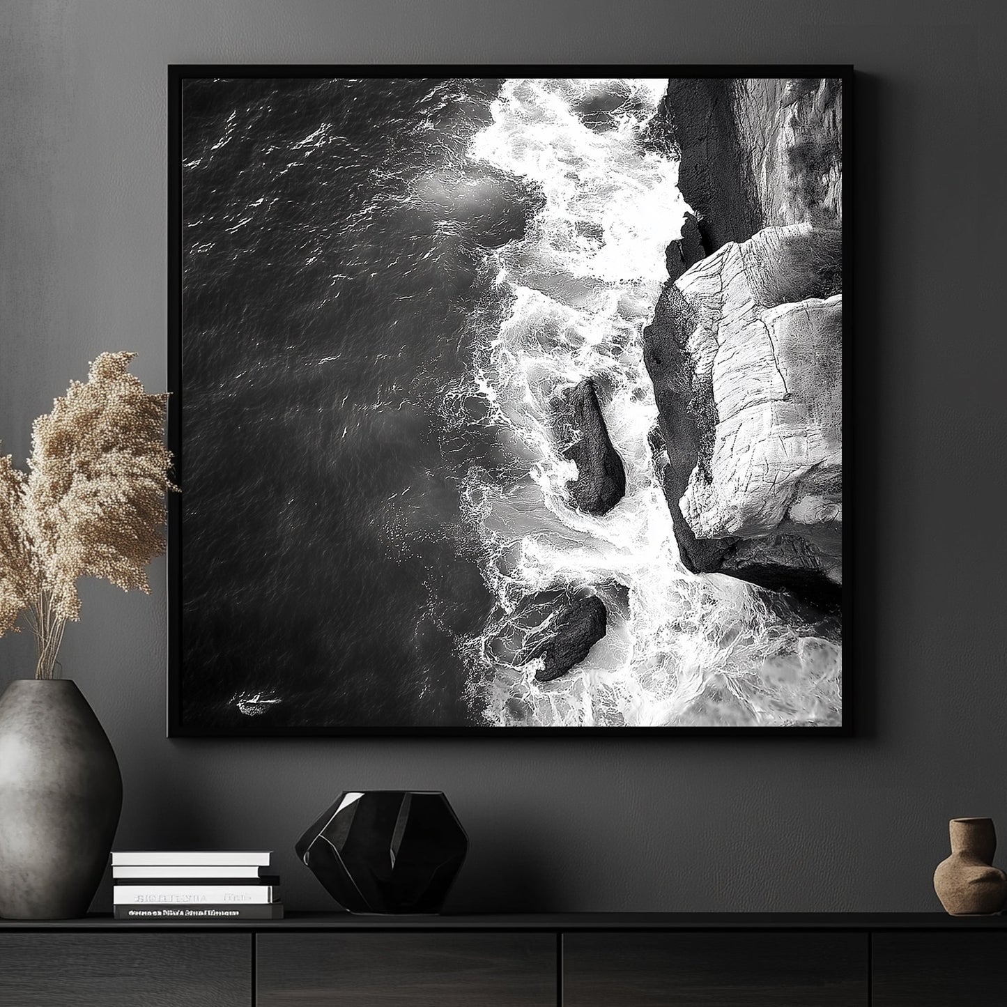 Black and white image of waves crashing against rocky cliffs, creating a dramatic coastal scene.