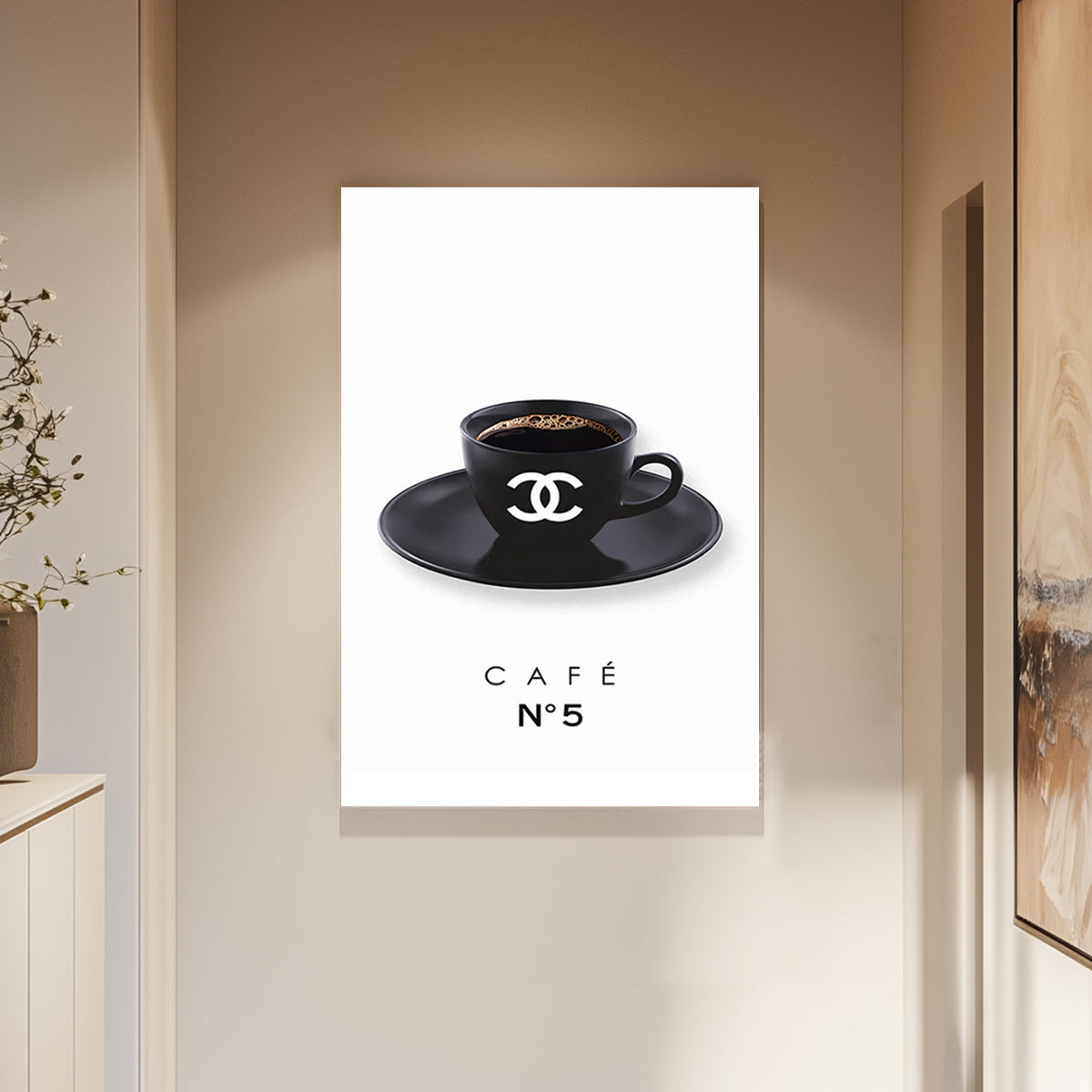 A minimalist art print of a branded black coffee cup with the Chanel logo, placed on a matching saucer, against a clean white background.
