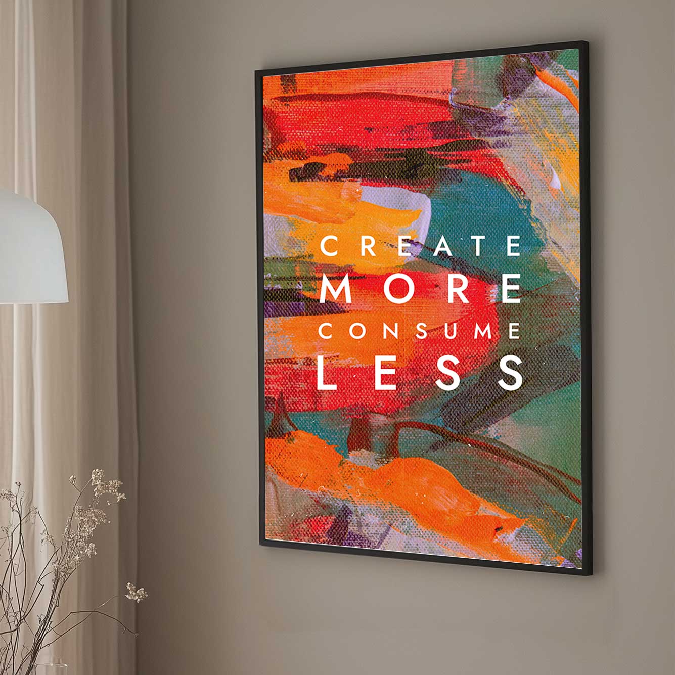 A colourful abstract canvas wall art print with bold strokes of orange, red, and green, overlaid with the motivational text "Create More Consume Less."