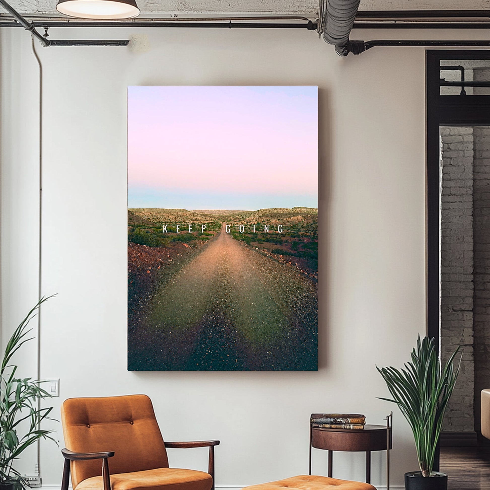 A metal wall art print of a peaceful dirt road stretches into the horizon under a gradient pastel sky, featuring the motivational text "Keep Going."