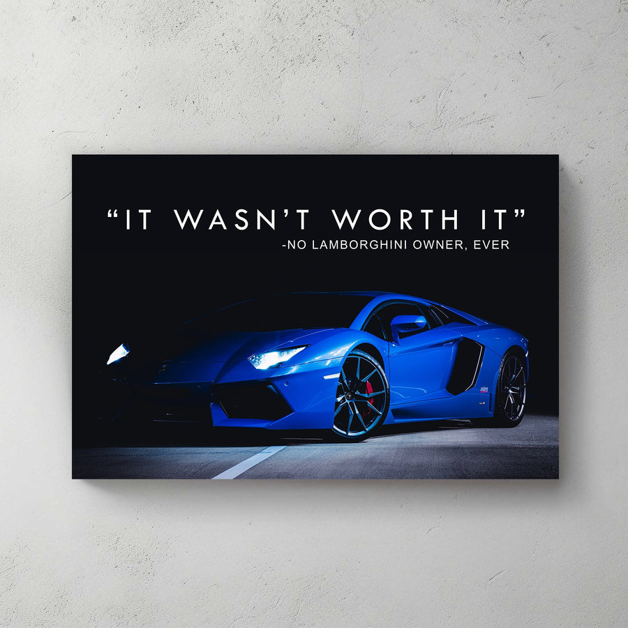A sleek metal print of a blue Lamborghini photographed at night with illuminated headlights, accompanied by the text "It wasn’t worth it – no Lamborghini owner, ever."