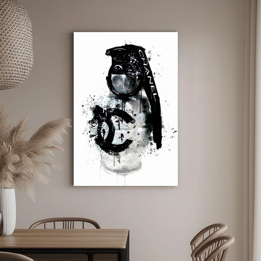 A wall art print of a Chanel branded grenade dripping with black ink splatters on a white background, combining luxury and chaos.