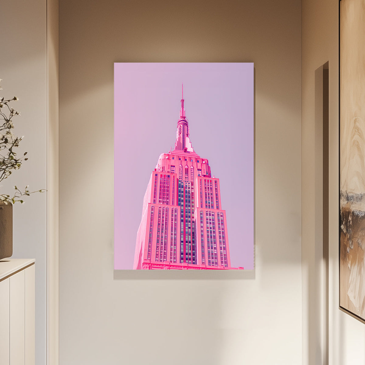 A pink wall art print of the Empire State Building in soft pink tones against a pastel background, showcasing minimalistic modern architecture.