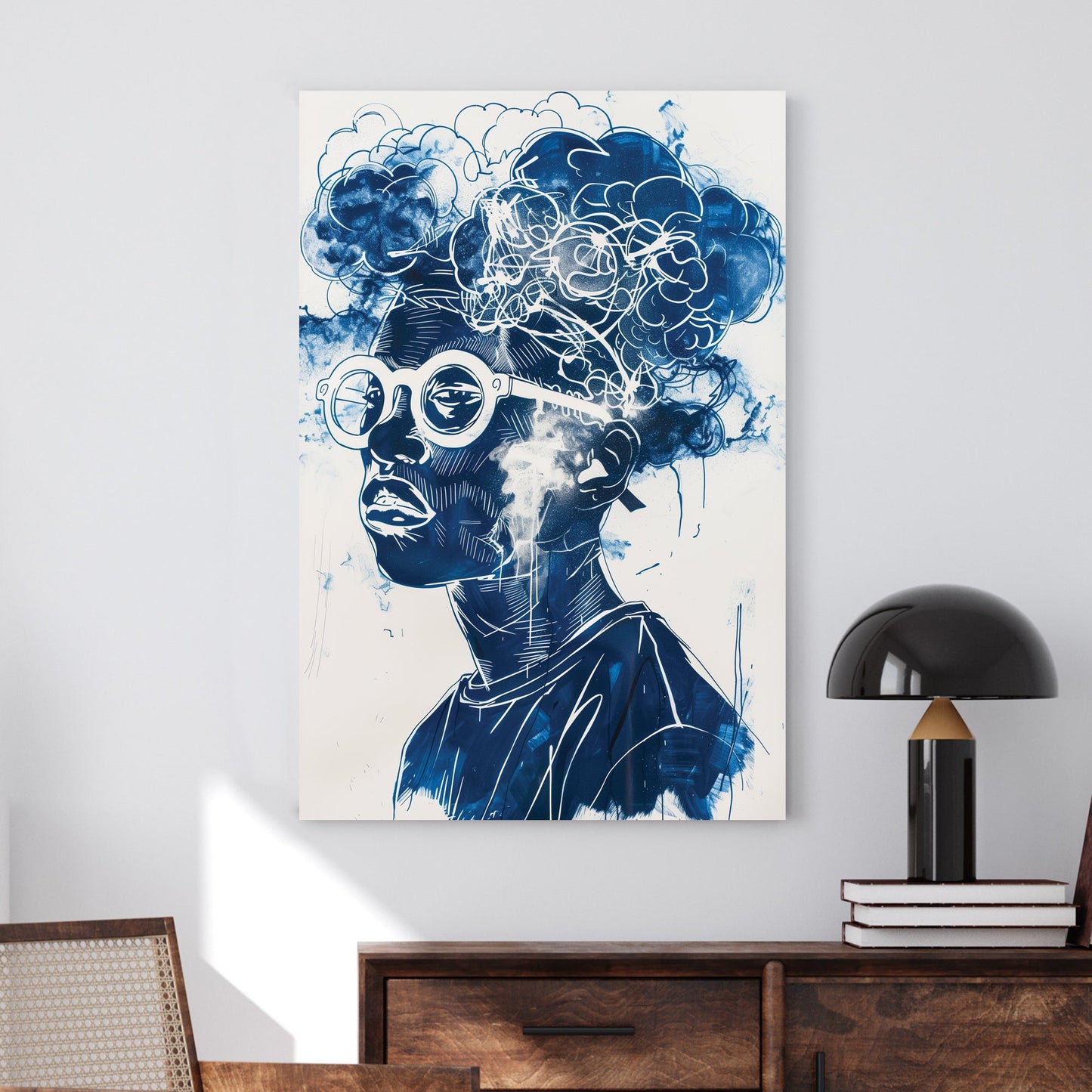 A contemporary graffiti-style wall art print of a person wearing round glasses, with abstract cloud formations seamlessly merging into their hair, rendered in deep blue and white tones.