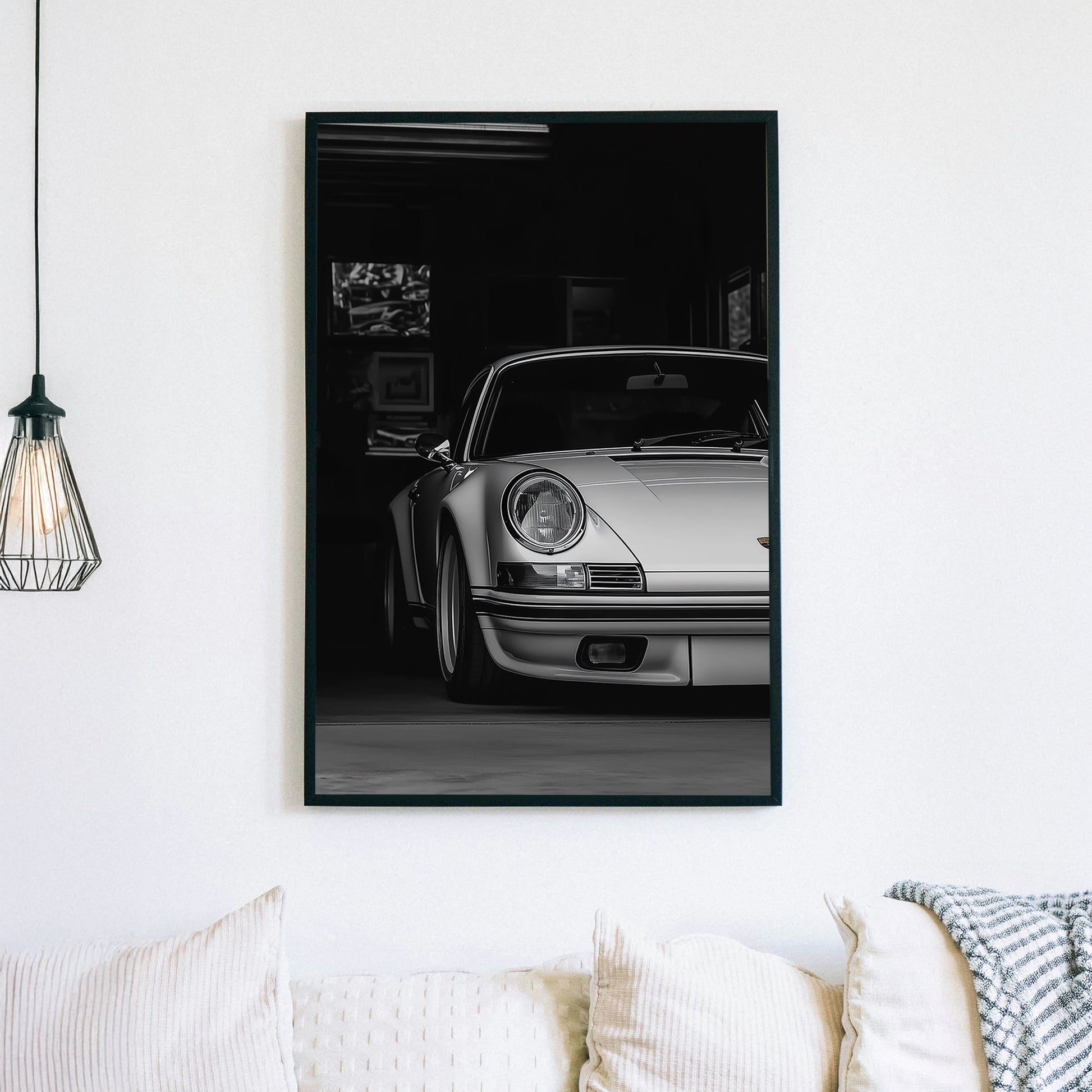 A black-and-white digital wall art print of a silver Porsche emerging from the shadows of a dimly lit garage, showcasing its refined curves and elegance.