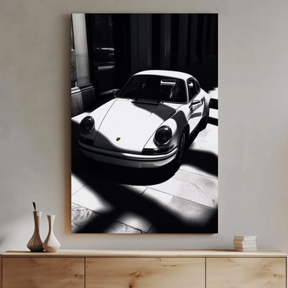 A striking black and white digital wall art print of a classic Porsche 911, captured in dramatic light and shadow, emphasizing its sleek design