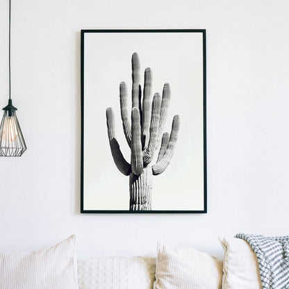 A black and white minimalistic wall art print of a towering saguaro cactus, highlighting its texture and natural elegance against a clean backdrop