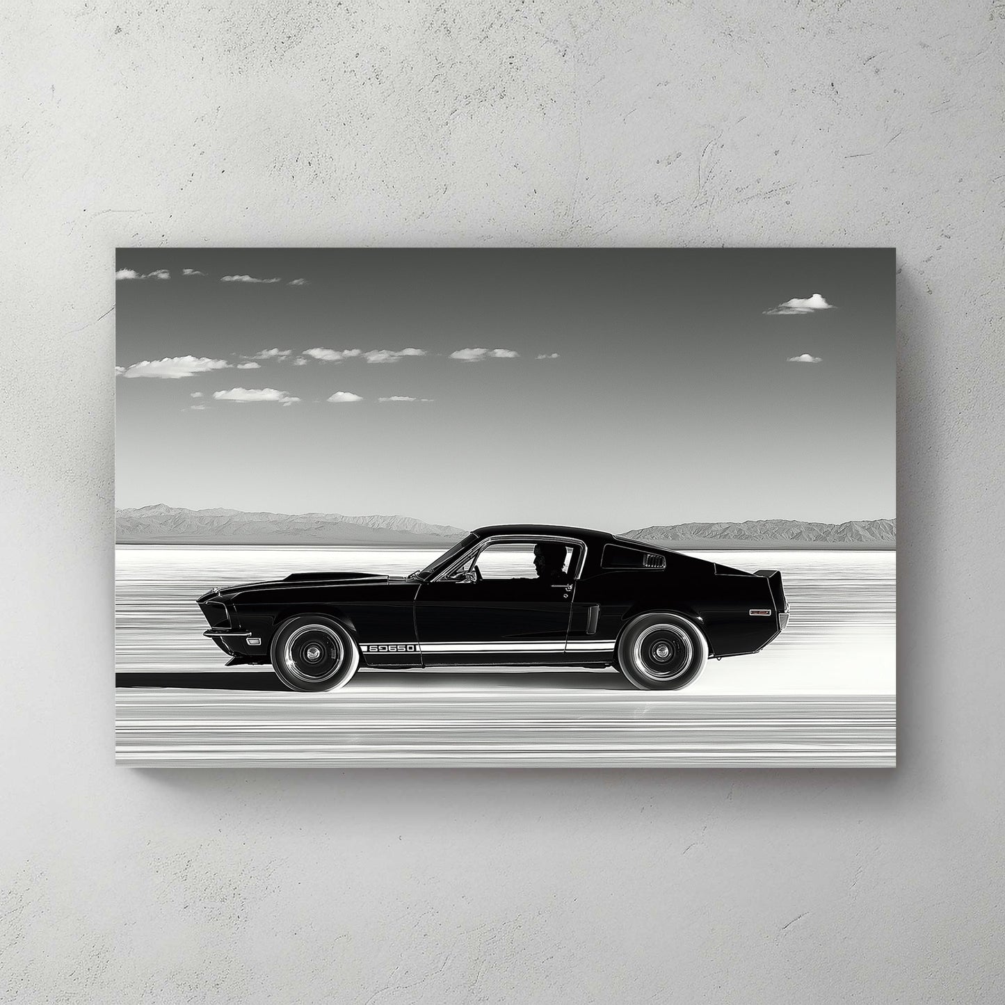 A black-and-white wall art print of a classic Ford Mustang speeding across the salt flats, with a vast open sky and distant mountains in the background.