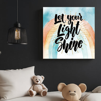 A motivational typography wall art print with the phrase “Let Your Light Shine” in bold script, set against a pastel watercolour rainbow with golden rays.