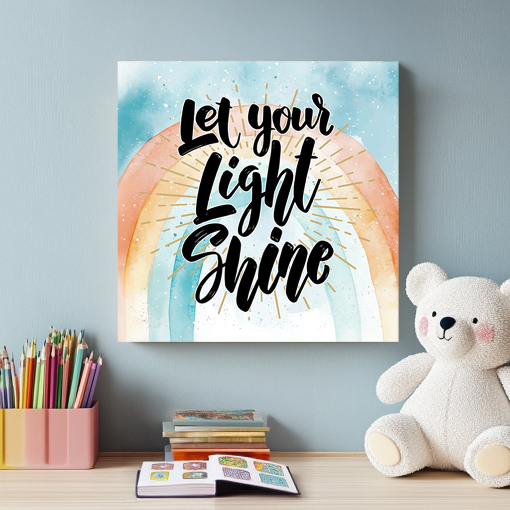 A motivational typography wall art print with the phrase “Let Your Light Shine” in bold script, set against a pastel watercolour rainbow with golden rays.