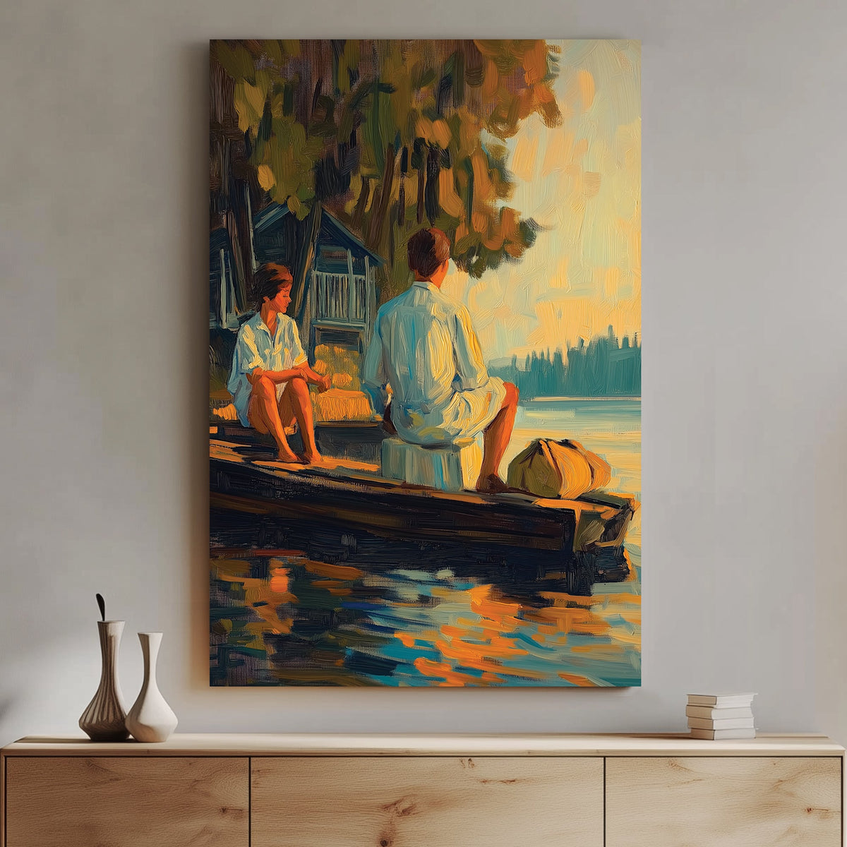 Oil-style wall art of a couple sitting on a wooden dock at sunset, with reflections on the water and a rustic cabin in the background.