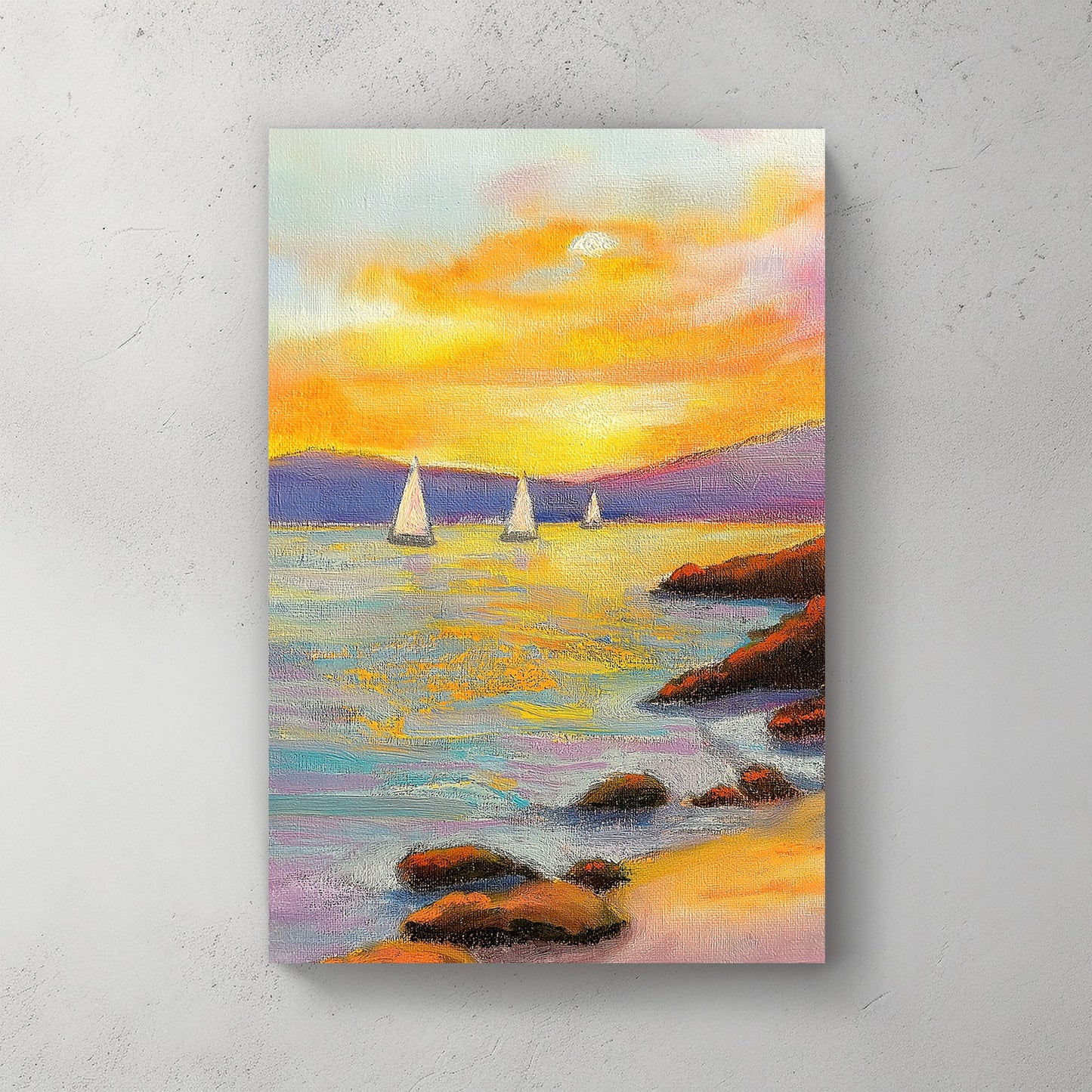 Vivid oil wall art of a sunset over the ocean, with sailboats in the distance and a rocky shoreline in the foreground.