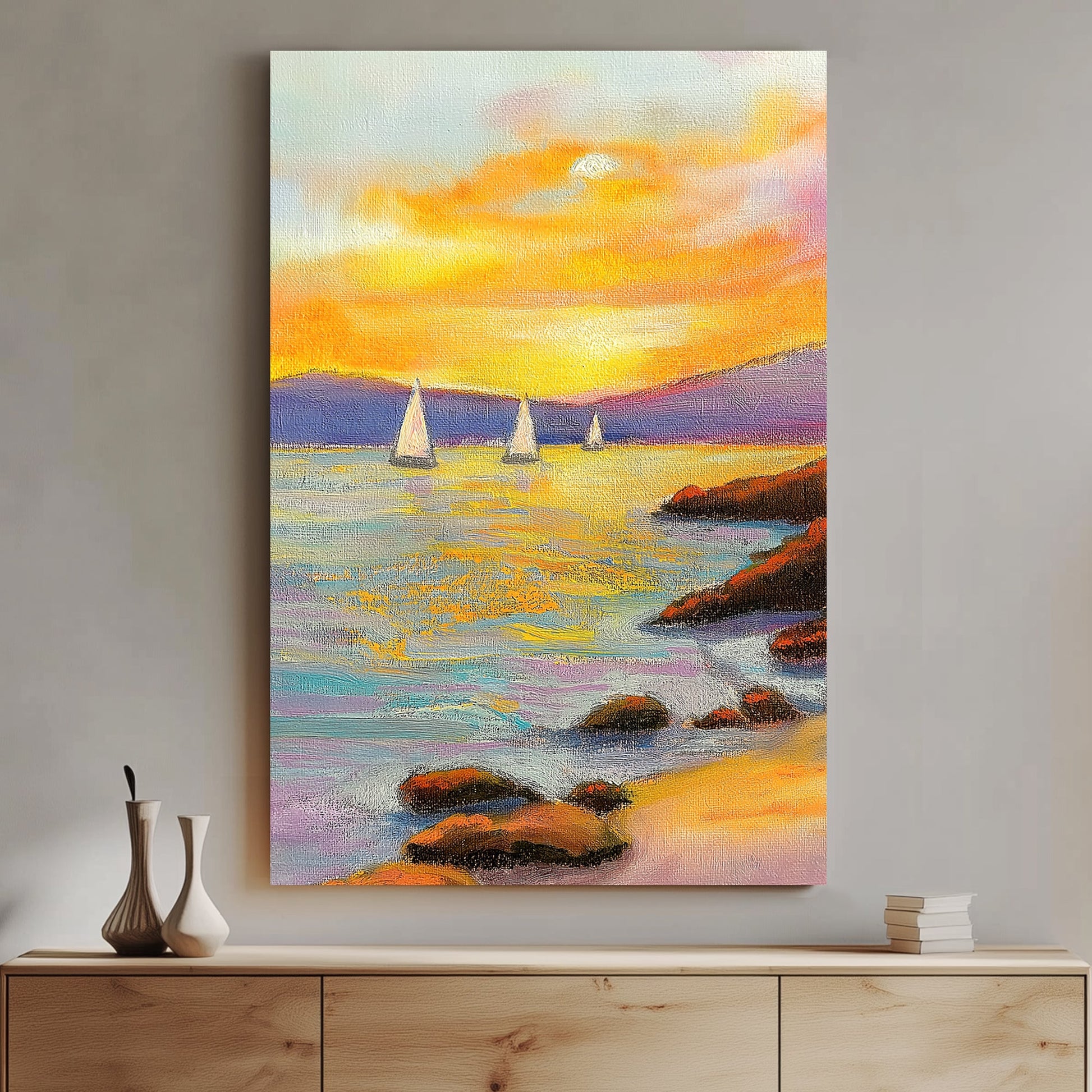 Vivid oil wall art of a sunset over the ocean, with sailboats in the distance and a rocky shoreline in the foreground.