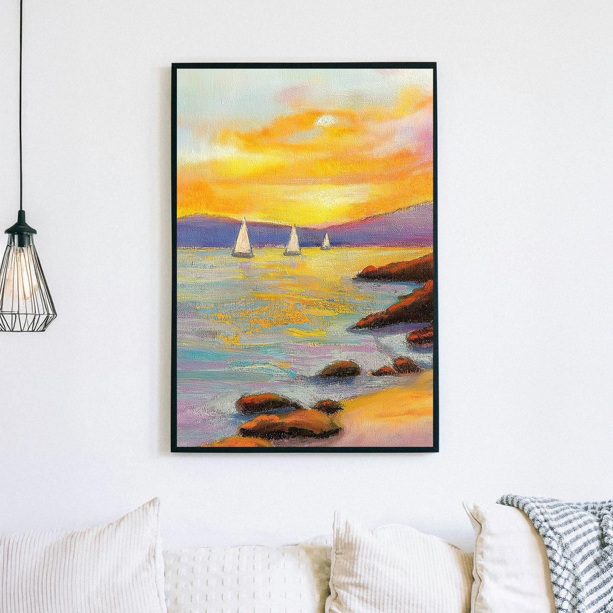 Vivid oil wall art of a sunset over the ocean, with sailboats in the distance and a rocky shoreline in the foreground.