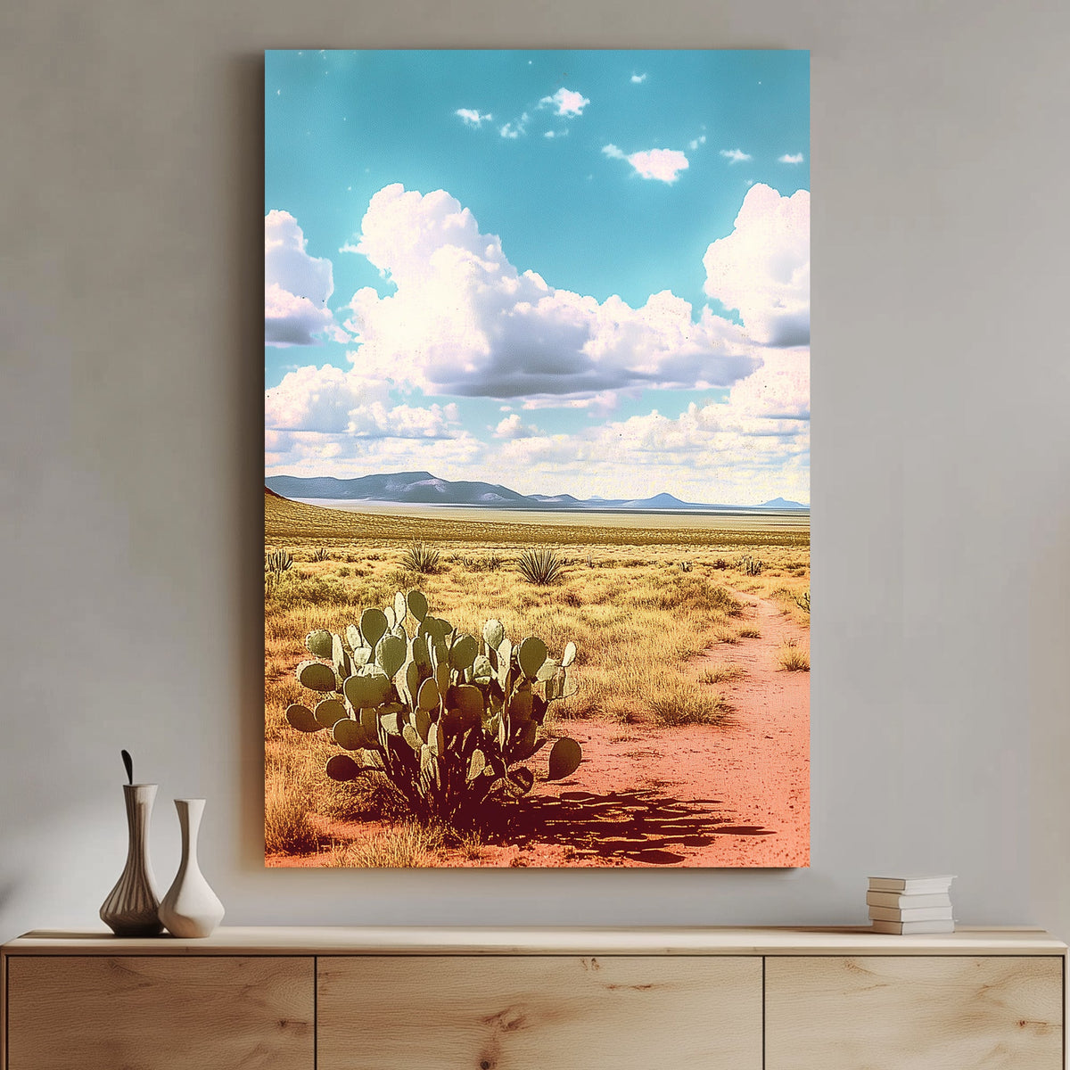 Vintage-style desert landscape with a prickly pear cactus, golden sand, distant mountains, and a vast blue sky filled with fluffy clouds.