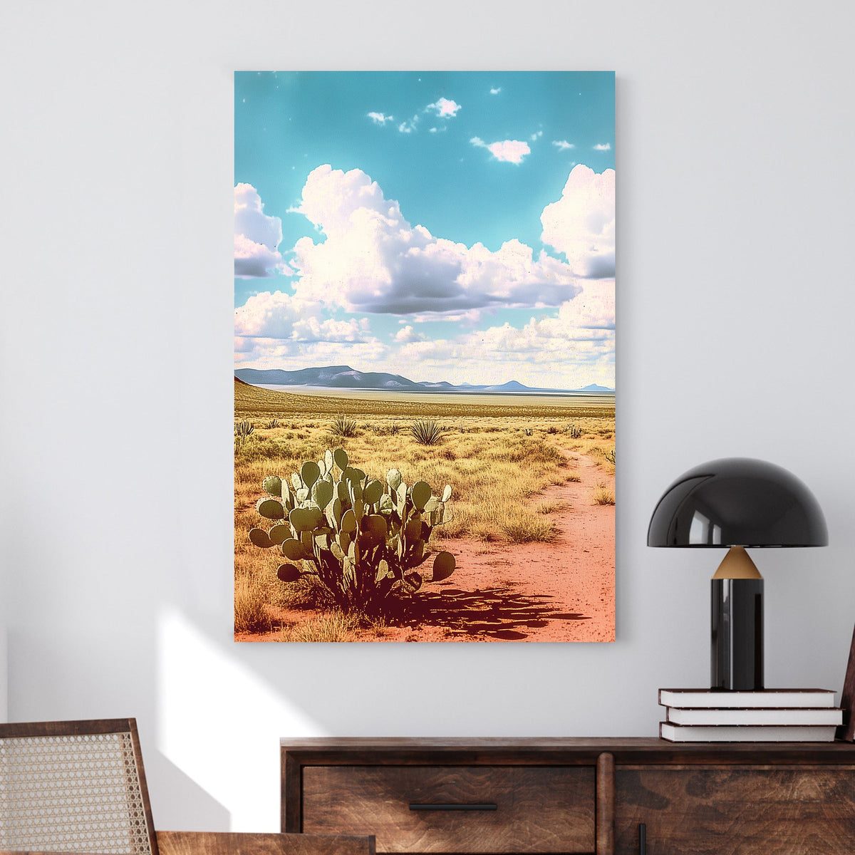 Vintage-style desert landscape with a prickly pear cactus, golden sand, distant mountains, and a vast blue sky filled with fluffy clouds.