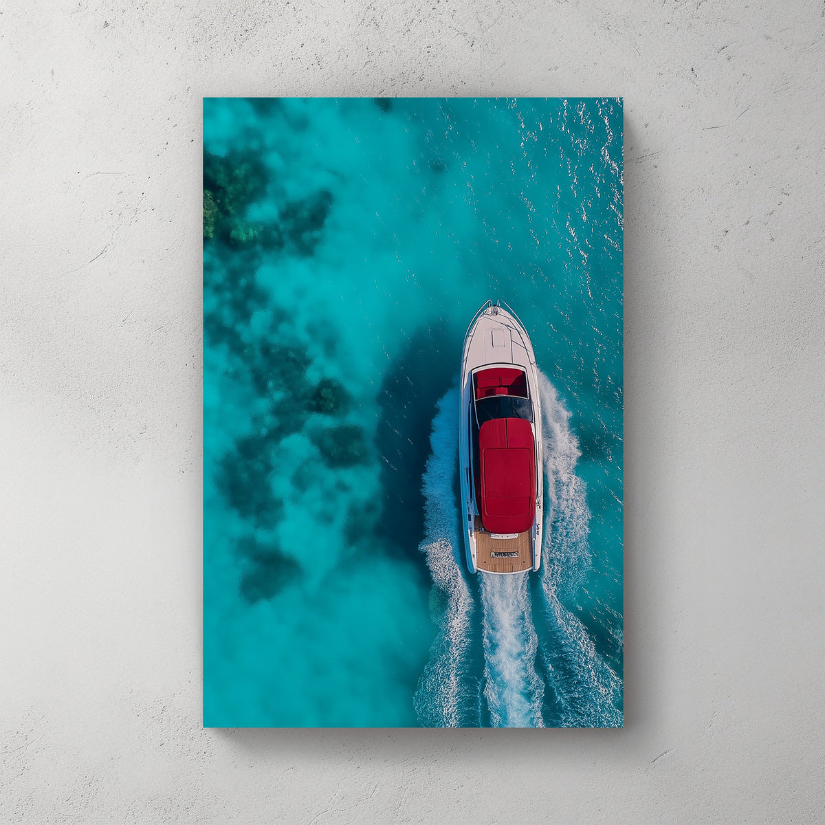 Aerial view of a white yacht with a red canopy cruising through turquoise ocean waters, leaving a foamy wake.