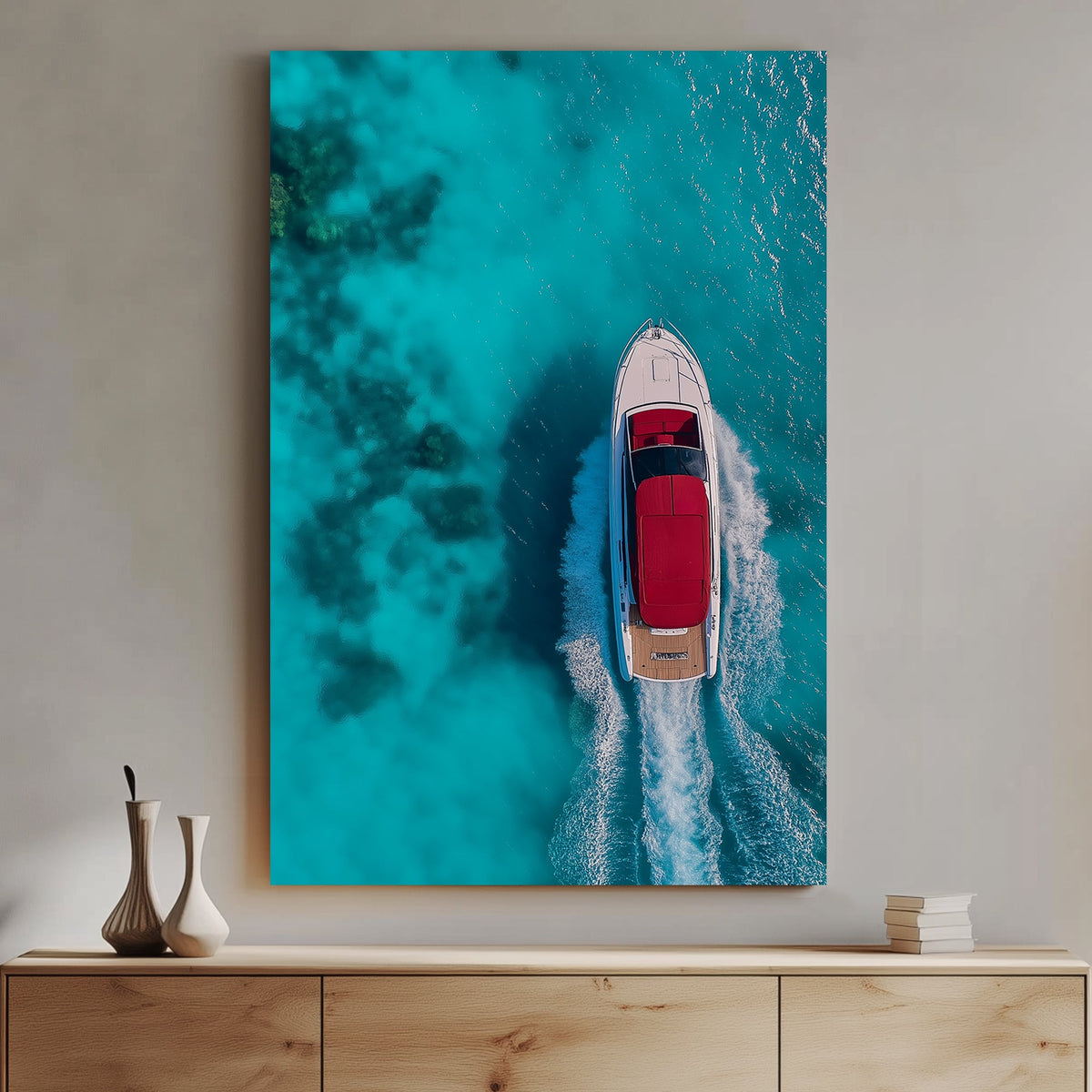 Aerial view of a white yacht with a red canopy cruising through turquoise ocean waters, leaving a foamy wake.