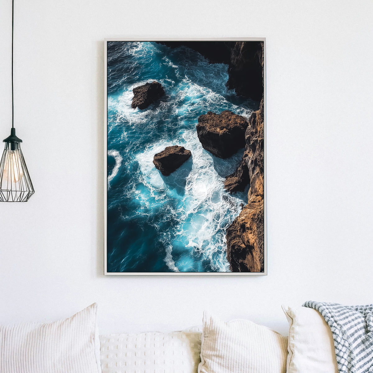 Dramatic ocean wall art featuring waves crashing against rocky cliffs in deep blue tones.