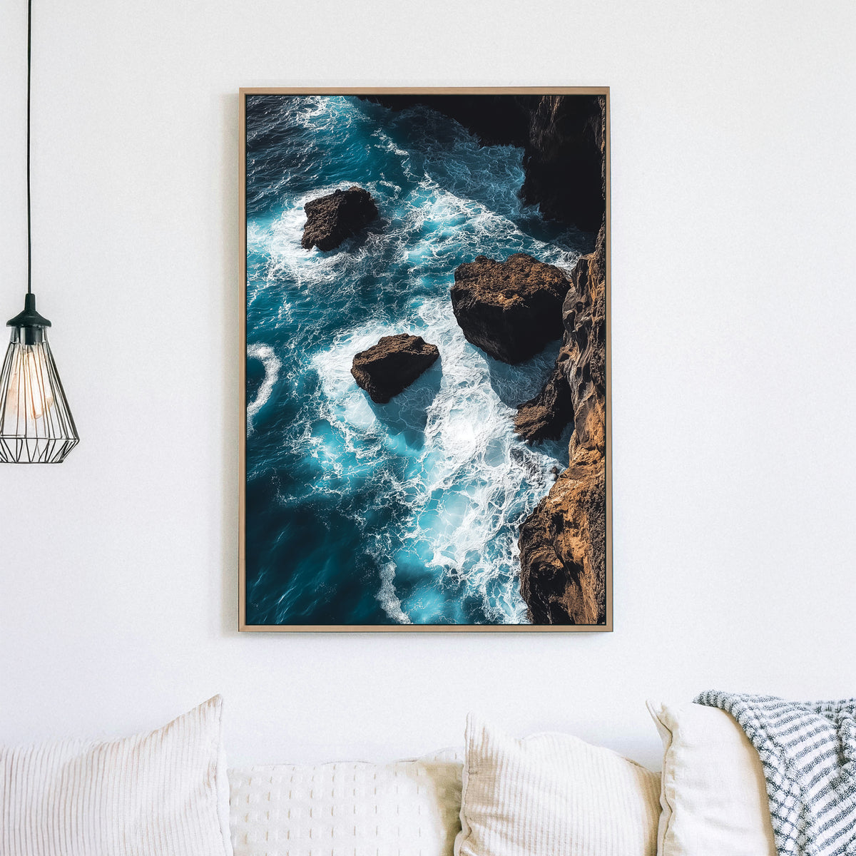 Dramatic ocean wall art featuring waves crashing against rocky cliffs in deep blue tones.