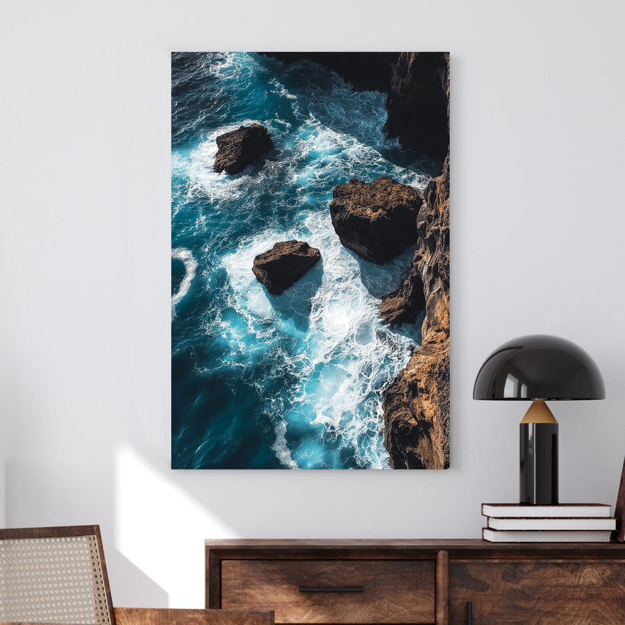 Dramatic ocean wall art featuring waves crashing against rocky cliffs in deep blue tones.