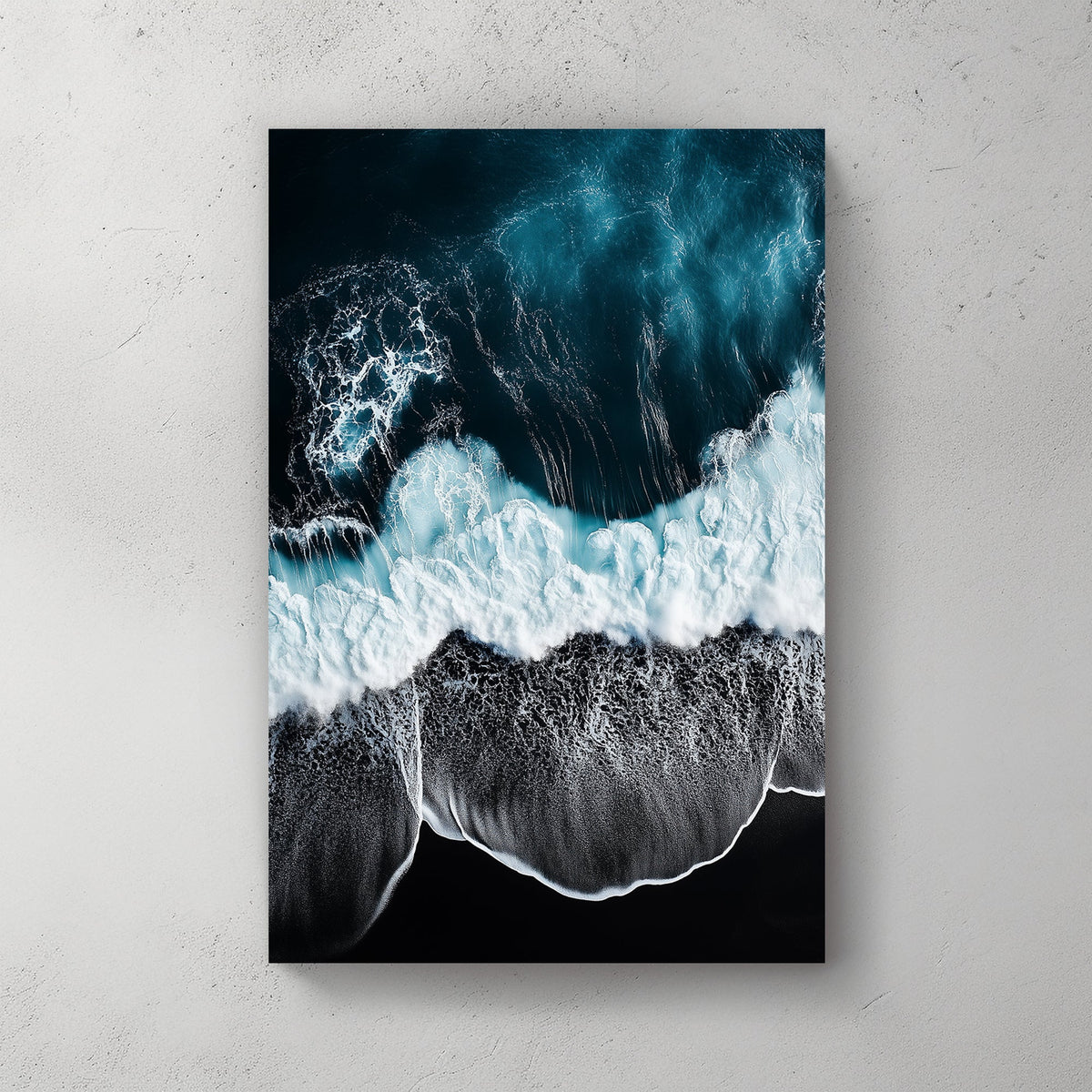 Aerial ocean wall art with deep blue waves crashing onto a black sand beach.