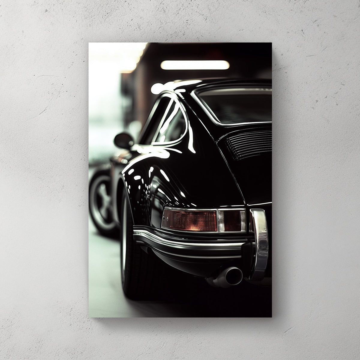 Close-up of a classic black Porsche with reflective chrome details in a dimly lit garage.