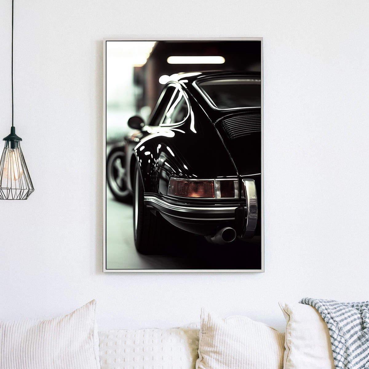 Close-up of a classic black Porsche with reflective chrome details in a dimly lit garage.