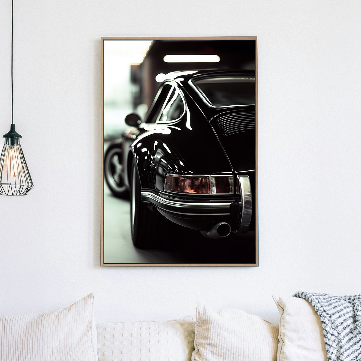 Close-up of a classic black Porsche with reflective chrome details in a dimly lit garage.