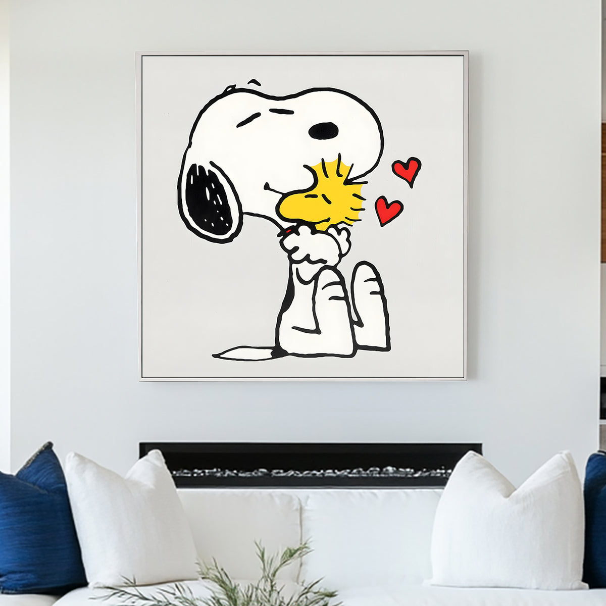 A piece of wall art featuring cartoon characters Snoopy and Woodstock from the Peanuts comic strip, with bold black outlines, crisp white space, and soft pops of color. The artwork shows Snoopy giving Woodstock a hug, with floating hearts in the air.