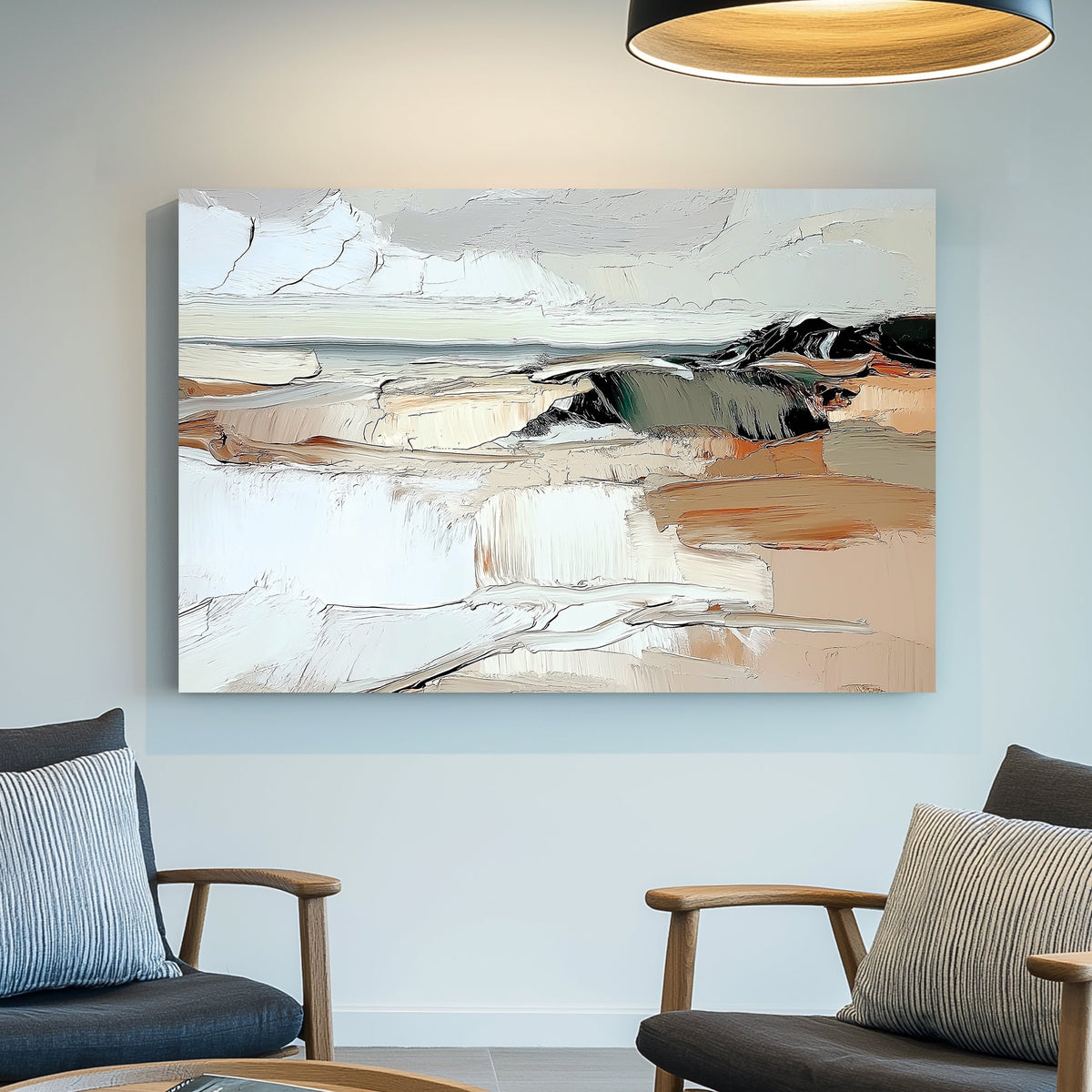 An abstract coastal landscape canvas print with textured brushstrokes in beige, white, gray, and black, displayed on a light blue-gray wall in a modern living room setting with two wooden armchairs and a hanging light fixture.