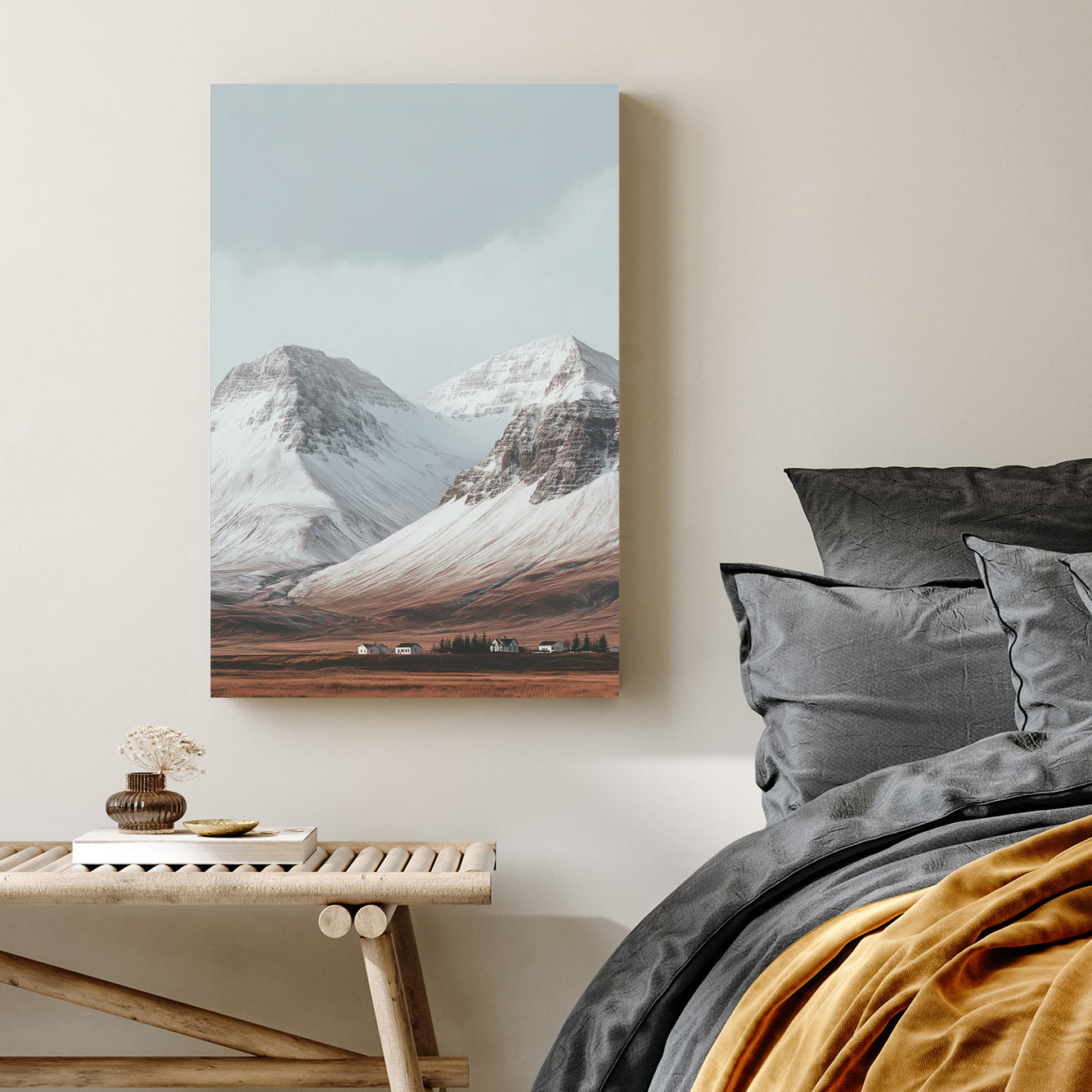 Snowy mountain landscape with cabins on a golden plain beneath grey skies