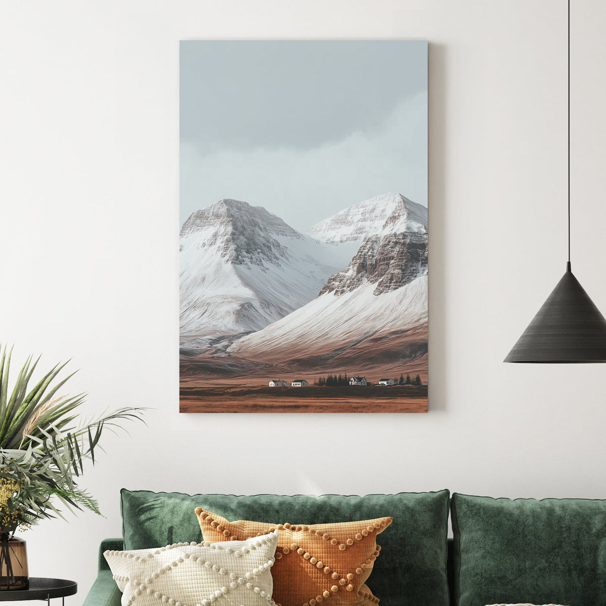 Snowy mountain landscape with cabins on a golden plain beneath grey skies